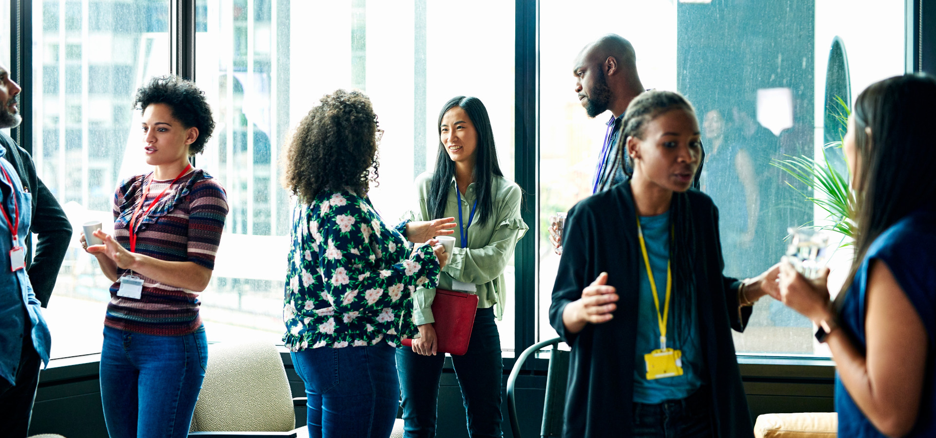 International alumni stand together in groups at an event and talk.