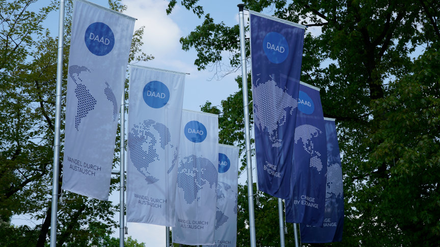 Flags with DAAD logo in front of the outer facade of the headquarters in Bonn.